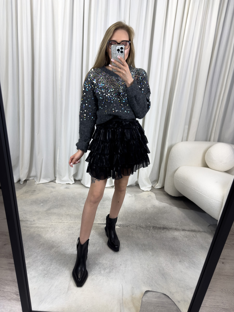 IMG_5829 Sweter Sequins ciemny szary z okrągłym dekoltem, błyszczącymi cekinami i klasycznym fasonem, zestawiony z czarną spódnicą mini z falbanami – elegancka stylizacja na zimowy wieczór.