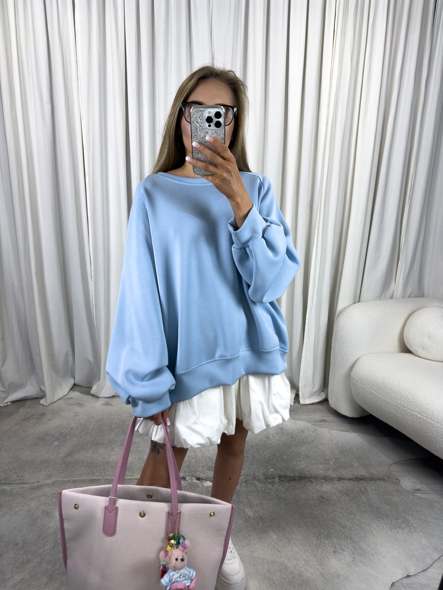 IMG_2797 Modelka w błękitnej bluzie oversize Casual z plisowaną spódnicą i pastelową torbą, stylizacja streetwear z nutą dziewczęcości.