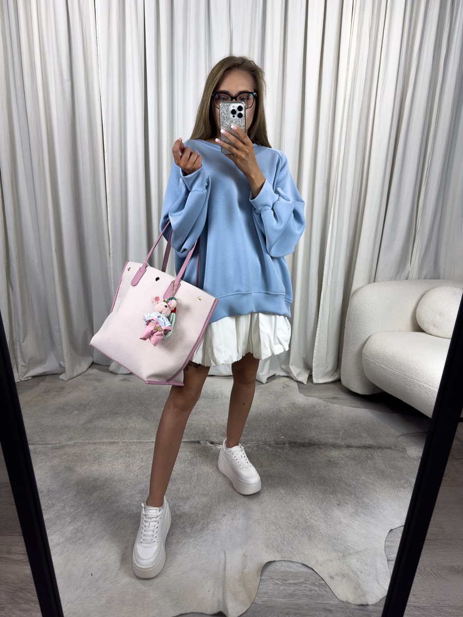 IMG_2804 Modelka w błękitnej bluzie oversize Casual z plisowaną spódnicą i pastelową torbą, stylizacja streetwear z nutą dziewczęcości.