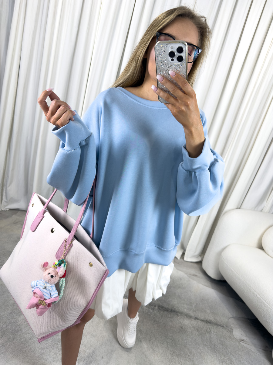 IMG_2806 Modelka w błękitnej bluzie oversize Casual z plisowaną spódnicą i pastelową torbą, stylizacja streetwear z nutą dziewczęcości.