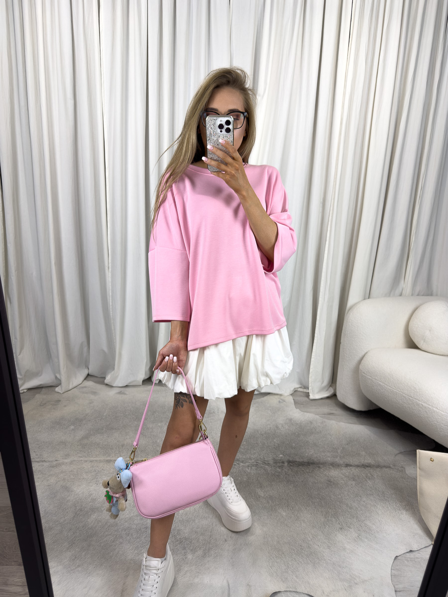 IMG_2925 Modelka w różowym t-shircie oversize Silky, zestawionym z białą spódnicą i pastelową torebką – stylizacja casualowa w stylu soft girl.