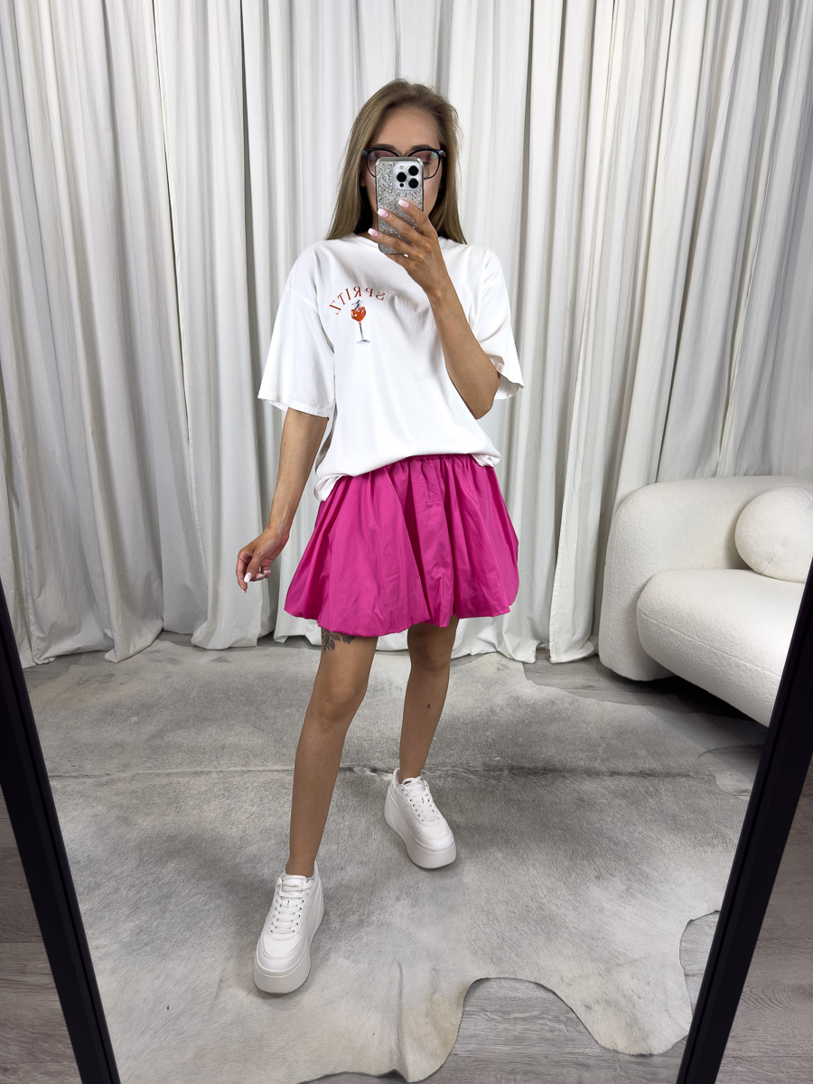 mini-spodnica-z-popeliny-cutie-fuksja Modelka w fuksjowej mini spódnicy z popeliny Cutie o balonowym kroju i elastycznym pasie – stylizacja z bluzą oversize i sneakersami, zdjęcie produktowe na potrzeby sklepu internetowego.