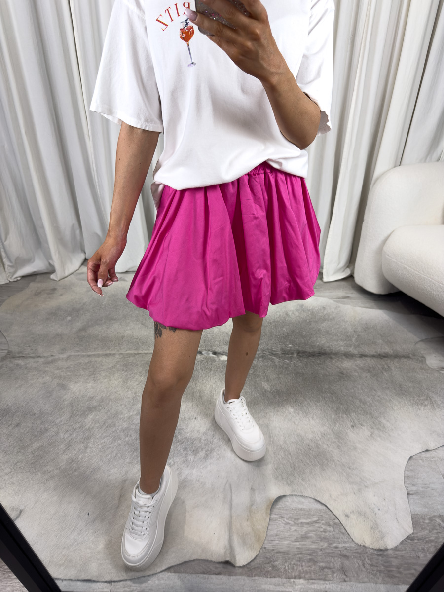 mini-spodnica-z-popeliny-cutie-fuksja Modelka w fuksjowej mini spódnicy z popeliny Cutie o balonowym kroju i elastycznym pasie – stylizacja z bluzą oversize i sneakersami, zdjęcie produktowe na potrzeby sklepu internetowego.