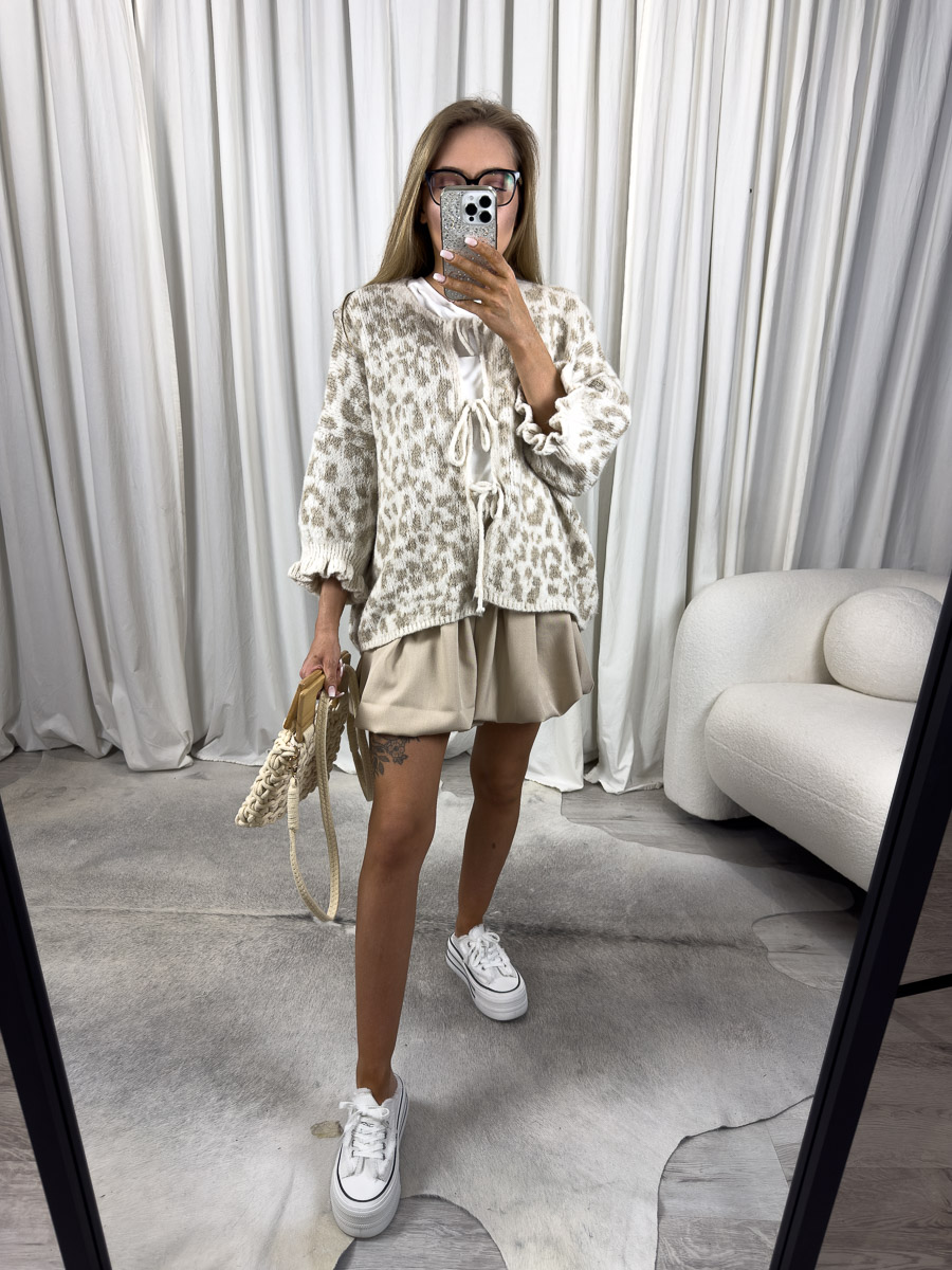 kardigan-tessa-bezowy-2 Zdjęcie produktowe sklepu internetowego z odzieżą damską – modelka w trampkach ubrana w kardigan Tessa beżowy w zwierzęcy print i krótkie spódnico-spodnie