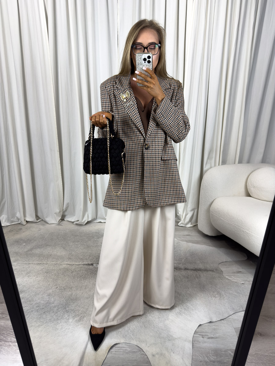 marynarka-o-prostym-kroju-glam-brazowa Modelka w marynarce o prostym kroju Glam z broszką i szerokimi spodniami. Zdjęcie produktowego sklepu internetowego z odzieżą damską.